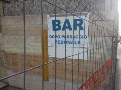 Un negoziante corre ai ripari inserendo un'indicazione del suo bar sull'impalcatura